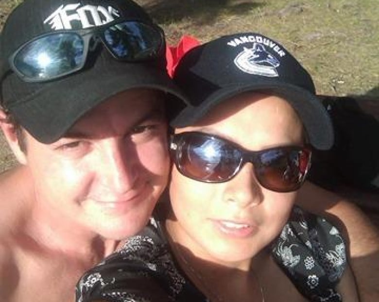 A man with a hat poses with a woman with sunglasses for a selfie.