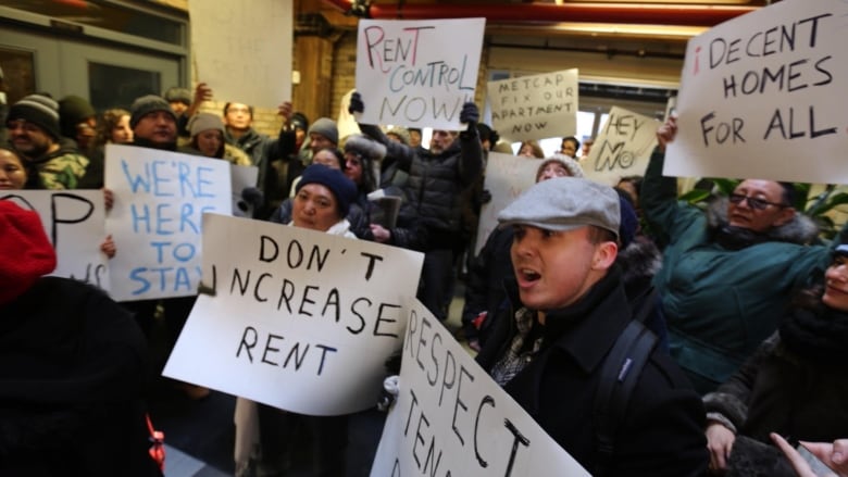 People hold up protest signs.