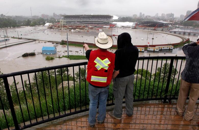 Two people look onto a flooded area.