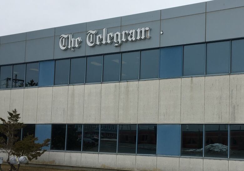 A logo for the St. John's Telegram is shown on the side of a building.