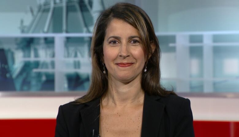 A medium shot of Rachel Curran, the head of public policy for Meta Canada. Curran smiles in a black jacket, a blurred studio background behind her.