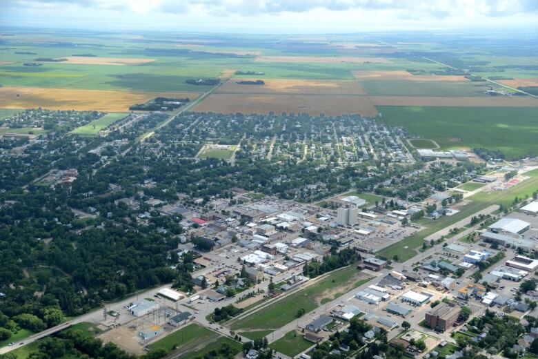 An aerial view shows a small city surrounded by farmland.