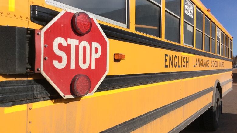 View of the side of a P.E.I. school bus, with stop sign prominent.