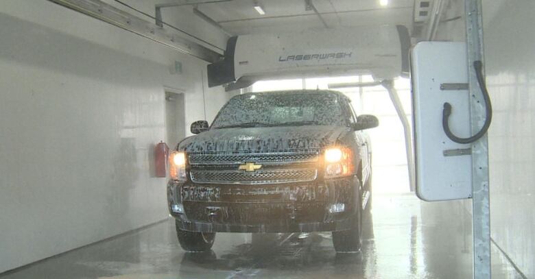 A black truck goes through a car wash.