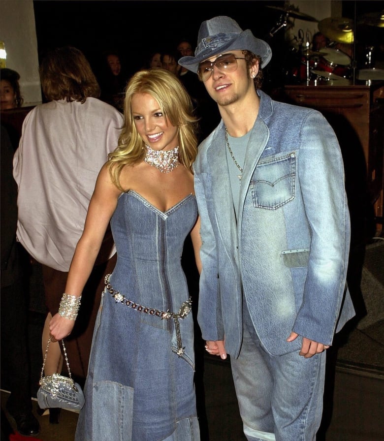 A young couple wears matching denim outfits at an event.