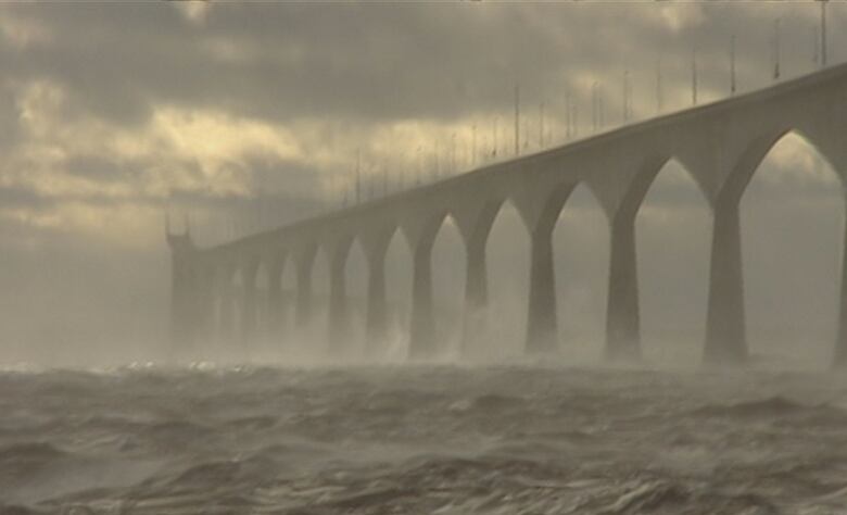 Waves crashing against bridge.