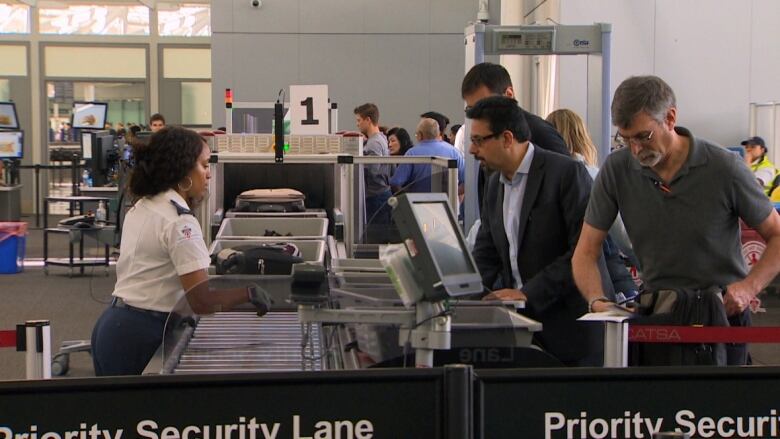 Passengers at an airport security checkpoint.