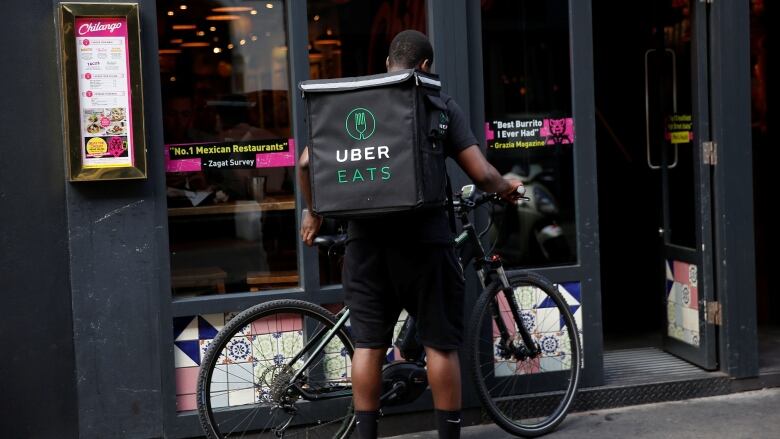 An UberEATS food delivery courier prepares his bike in London, Britain.