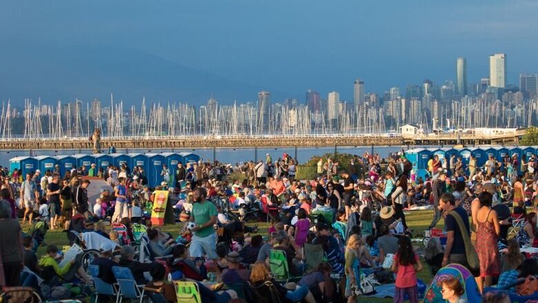 Crowds of people attend a music festival at a beach in Vancouver.