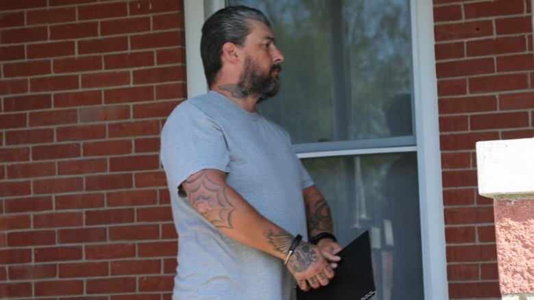 Side profile of man in handcuffs, walking 