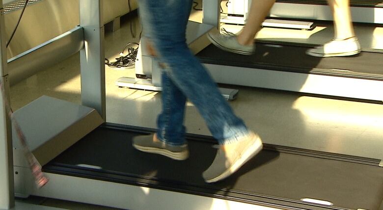 Legs on a treadmill desk.