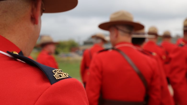 Officers in red uniforms and brown hats.