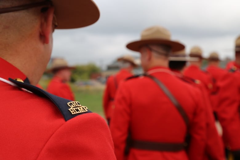 Officers in red uniforms and brown hats.