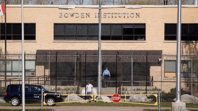 A prison entrance, with a gate and fence.