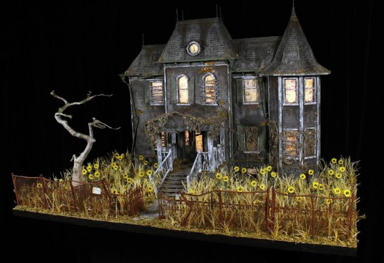 A spooky haunted house with a wild flower garden in front.