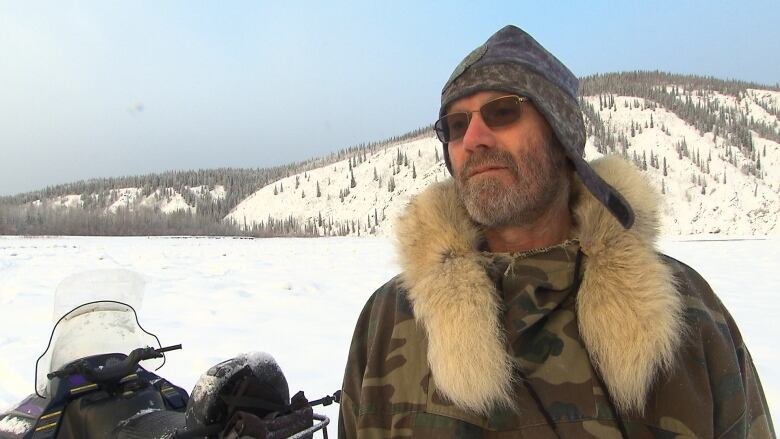 Man standing by a snowmobile