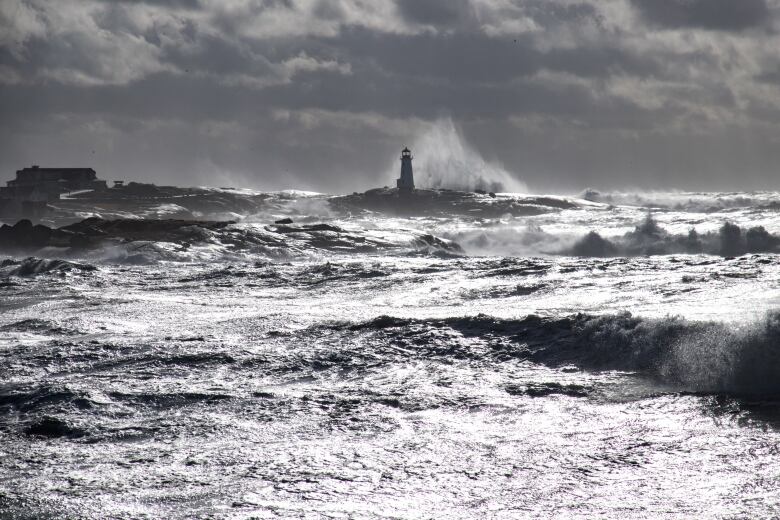 A lighthouse is bashed by waves.