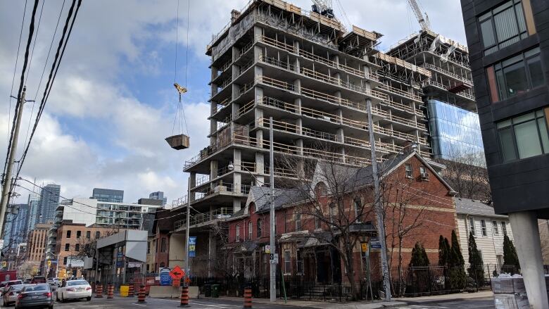 An office and condo building rises in a former residential neighbourhood.