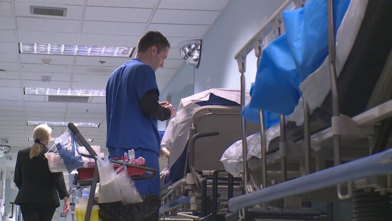 Nurses are in a hospital hallway with a stretcher nearby