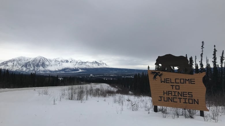 A roadside sign reads, 'Welcome to Haines Junction.'