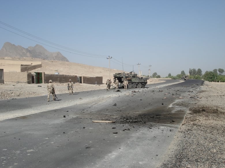 A road in the desert with a massive black mark on it.