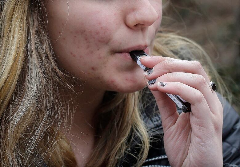  an unidentified 15-year-old high school student uses a vaping device.