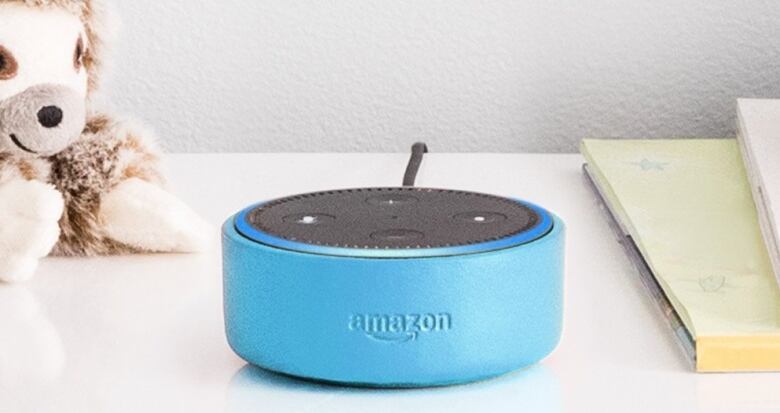 A blue oval shaped speaker on a table with the word Amazon engraved on it