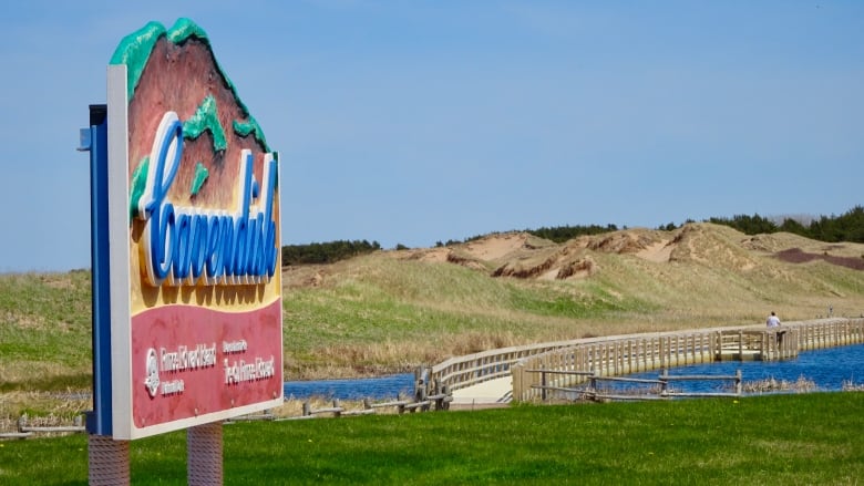 A sign saying Cavendish with sand dunes in the background.