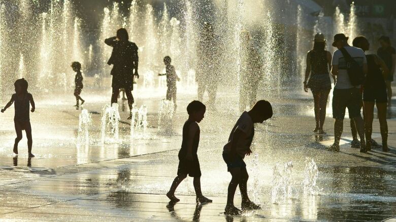 Children play in the water fountains at the Place des Arts in Montreal, Canada on a hot summer day July 3, 2018. (Photo by EVA HAMBACH / AFP)        (Photo credit should read EVA HAMBACH/AFP/Getty Images)