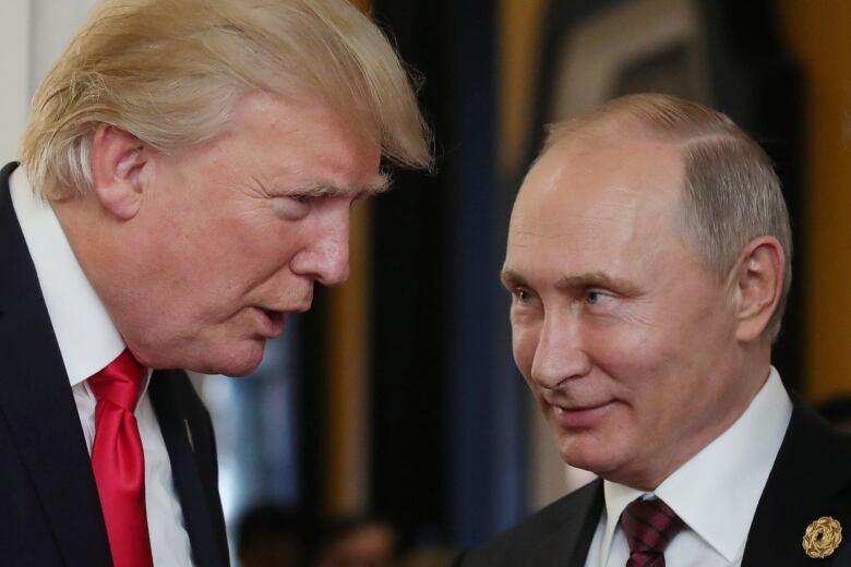 U.S. President Donald Trump chats with Russia's President Vladimir Putin as they attend the Asia-Pacific Economic Cooperation (APEC) leaders' summit in the central Vietnamese city of Danang on November 11, 2017.