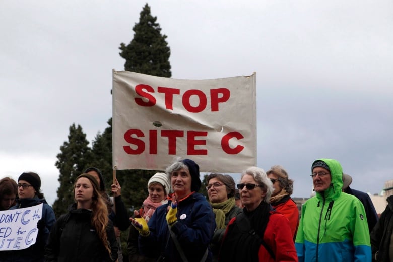 A group of people standing under a banner that says 