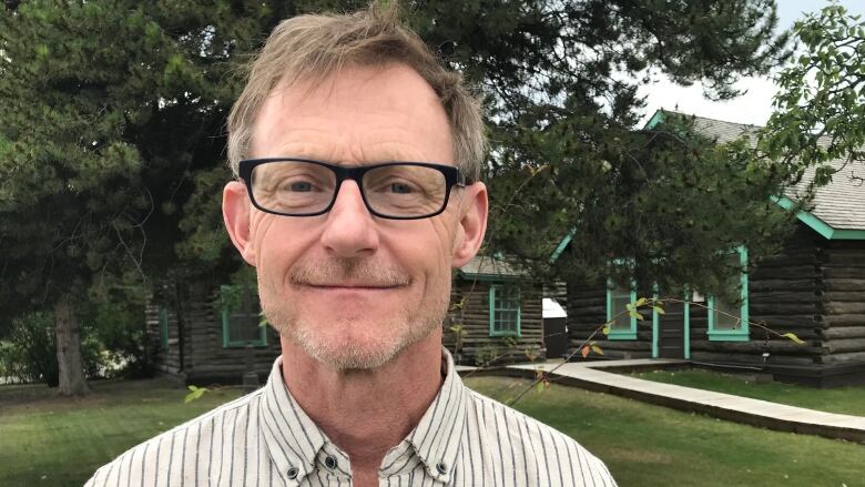 A close-up of a smiling white man with glasses.