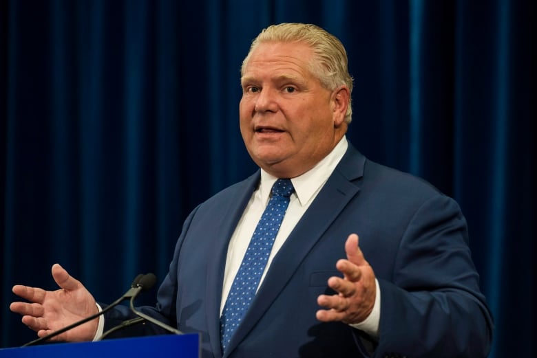 Man in a blue suit talking at a podium