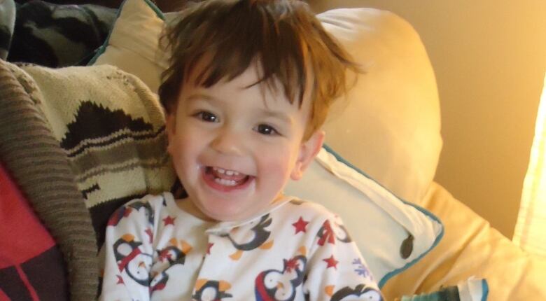 A smiling baby boy with brown hair.