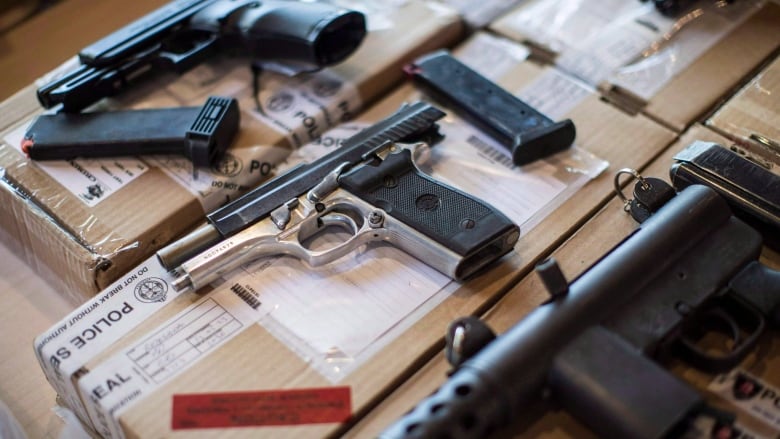 An assortment of guns and magazine clips.