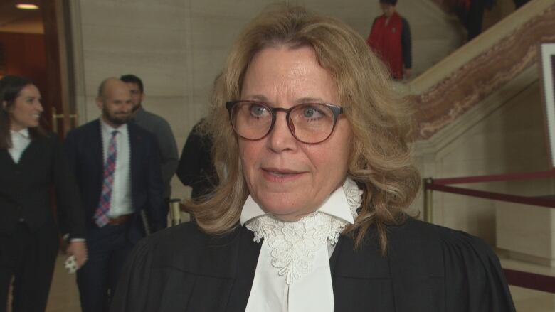 A lawyer speaks outside a courtrom.