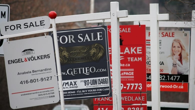 A row of 4 For Sale signs.