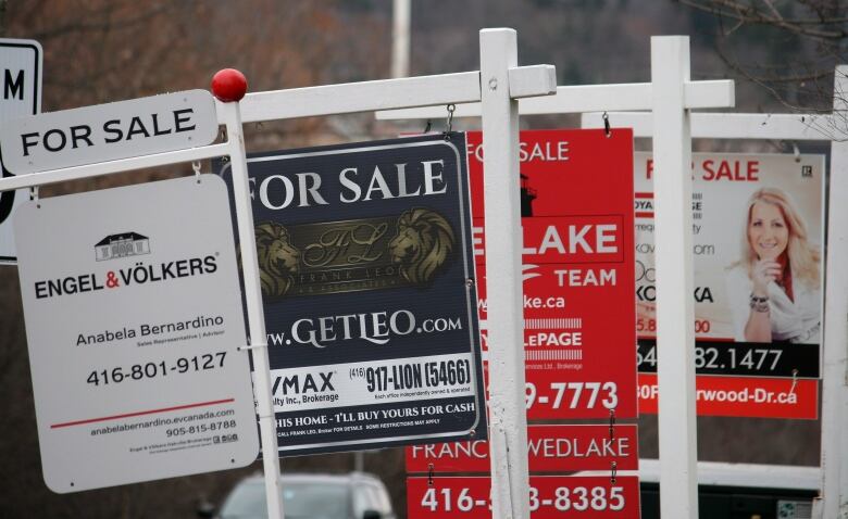 A row of 4 For Sale signs.