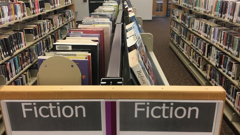 Books on shelves in the fiction section at a library