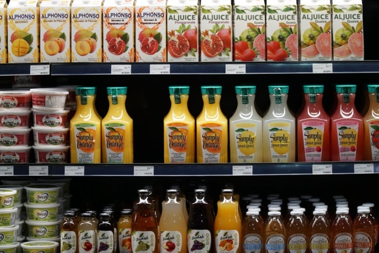 A fridge shelf at a grocery store, containing different brands of Canadian fruit juices.