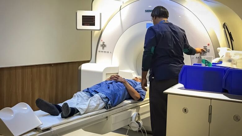 A sleep study subject, laying down in a big white machine, undergoes an MRI.