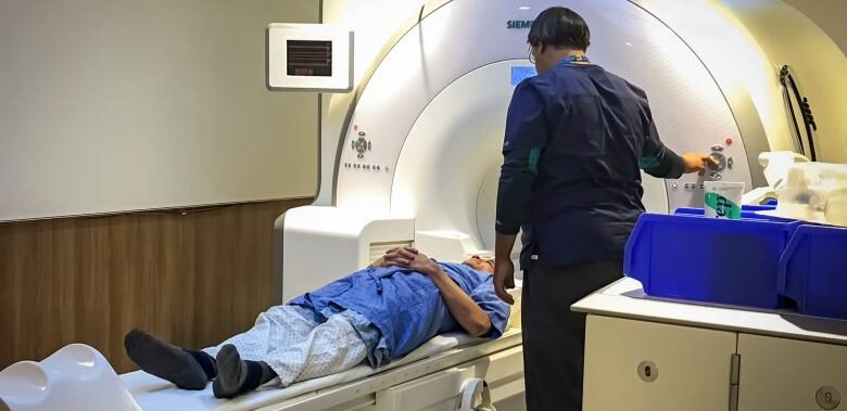 A sleep study subject, laying down in a big white machine, undergoes an MRI.