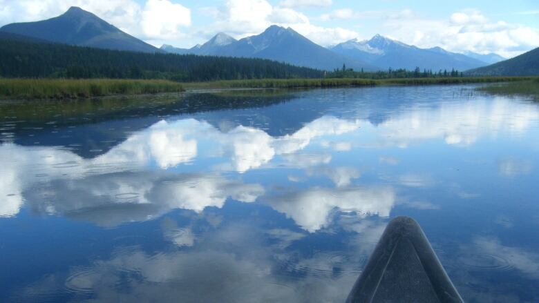 A canoe overlooking the lake and the mountains and hills in the horizon