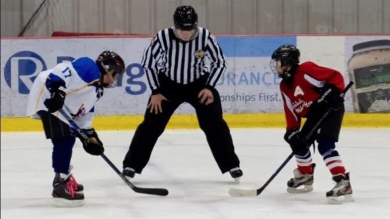 Two young players on the ice facing each other.