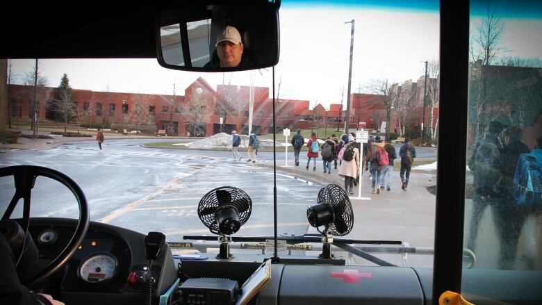 Students get off a bus at Cape Breton University.