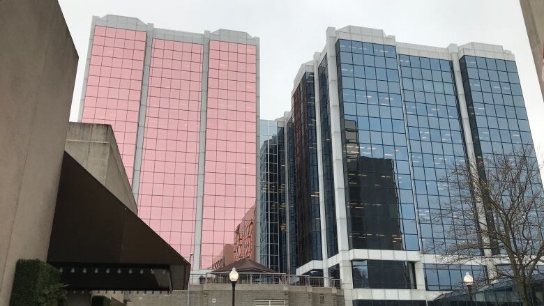 Two large office buildings with glass windows. 