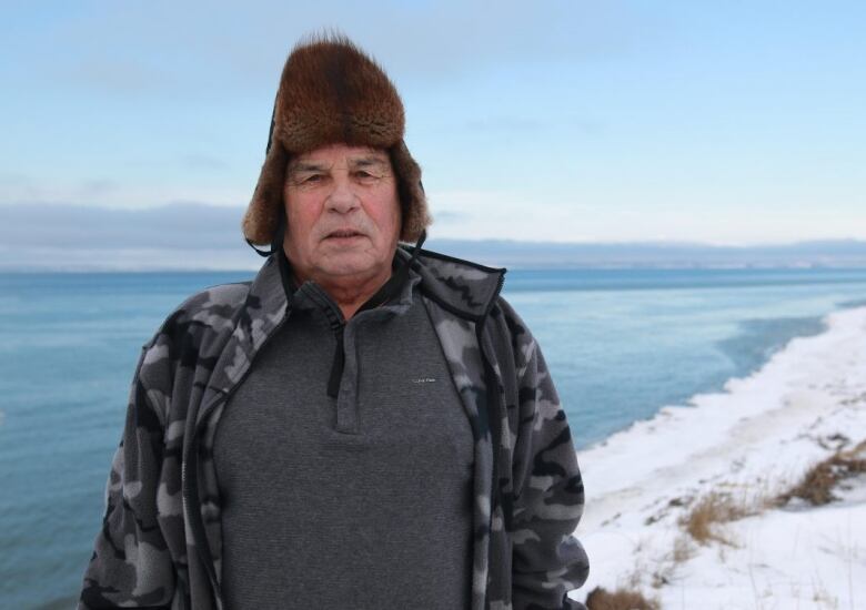 A man stands near the ocean