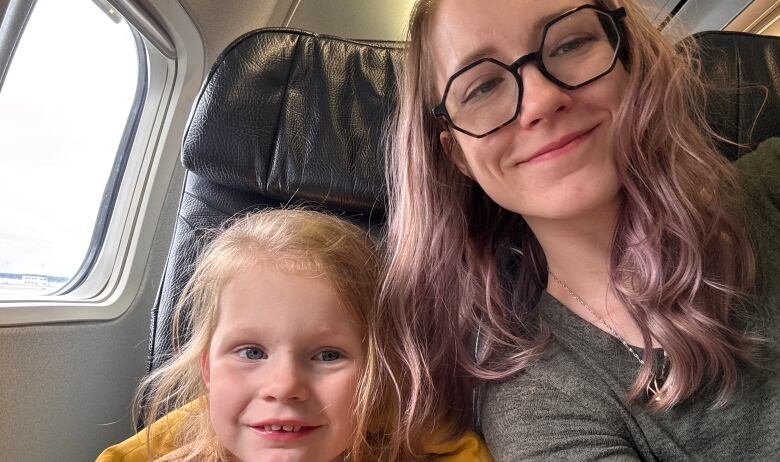 Taryn Zielke and 3-year-old daughter, Iris, sitting in seats on a WestJet plane. 