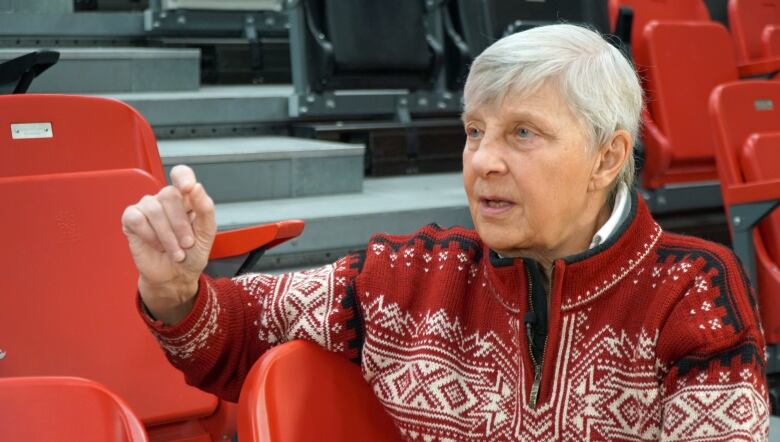 Woman sitting in red stadium chair