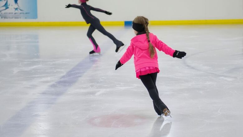 Young girl in pink dress skating